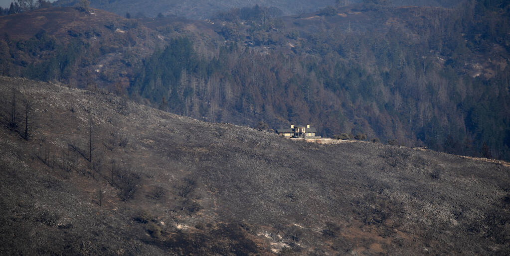 This house is surrounded by burned vegetation as far as the eye can see, but defensible space on top of a ridge protected it from the Glass fire in Santa Rosa’s Los Alamos Road area last October. (Kent Porter/The Press Democrat)