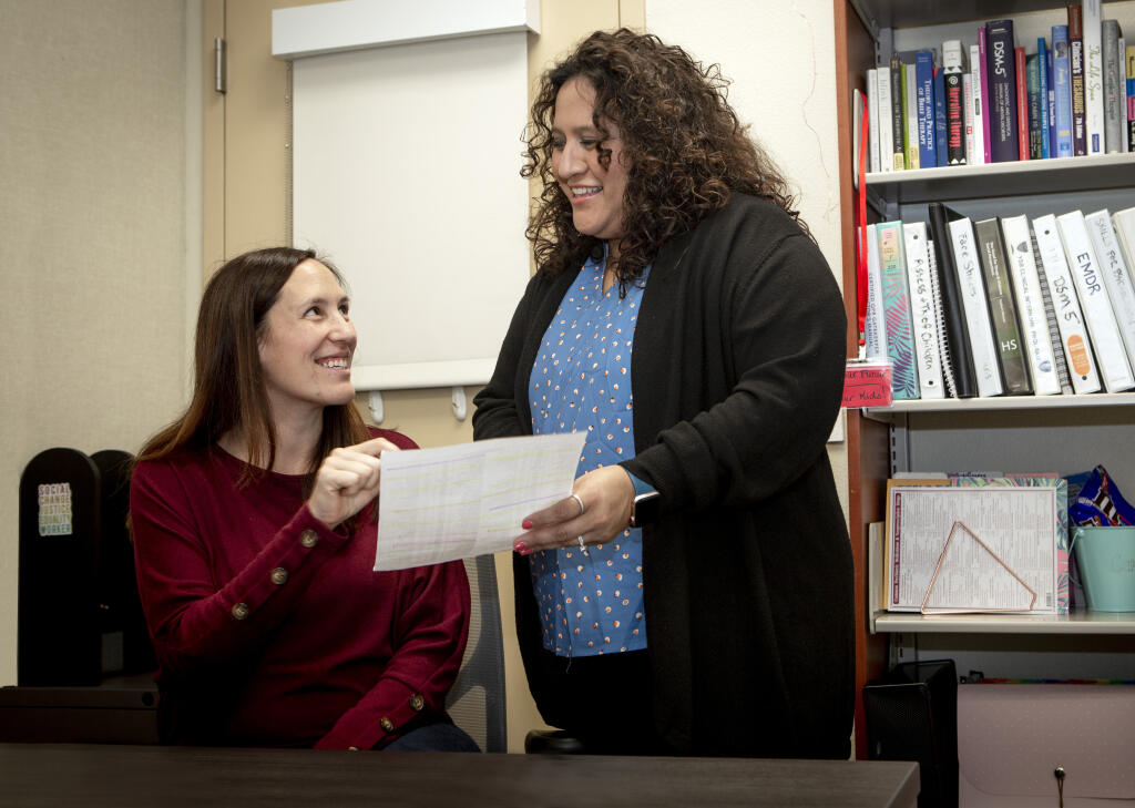 Social worker Camille Garcia, left, discusses a roster with bilingual community liaison Mariana Madrigal at the Wellness Center on the Sonoma Valley High School campus on Wednesday, Sept. 14, 2022.  (Robbi Pengelly/Index-Tribune)