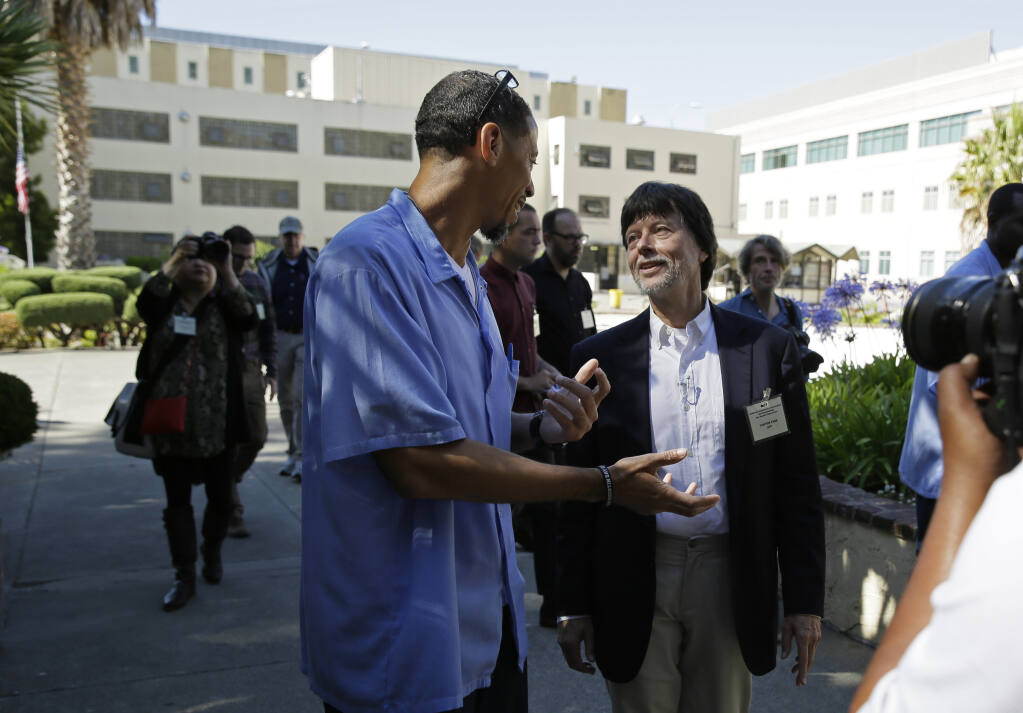 FILE - Filmmaker Ken Burns walks with inmate Rahsaan Thomas at San Quentin State Prison in San Quentin, Calif., on July 24, 2019. Thomas, a co-host of Ear Hustle, the Pulitzer Prize-nominated podcast produced behind bars, was released from San Quentin State Prison on Wednesday, Feb. 8,2023, a year after California's governor commuted his sentence. (AP Photo/Eric Risberg, File)