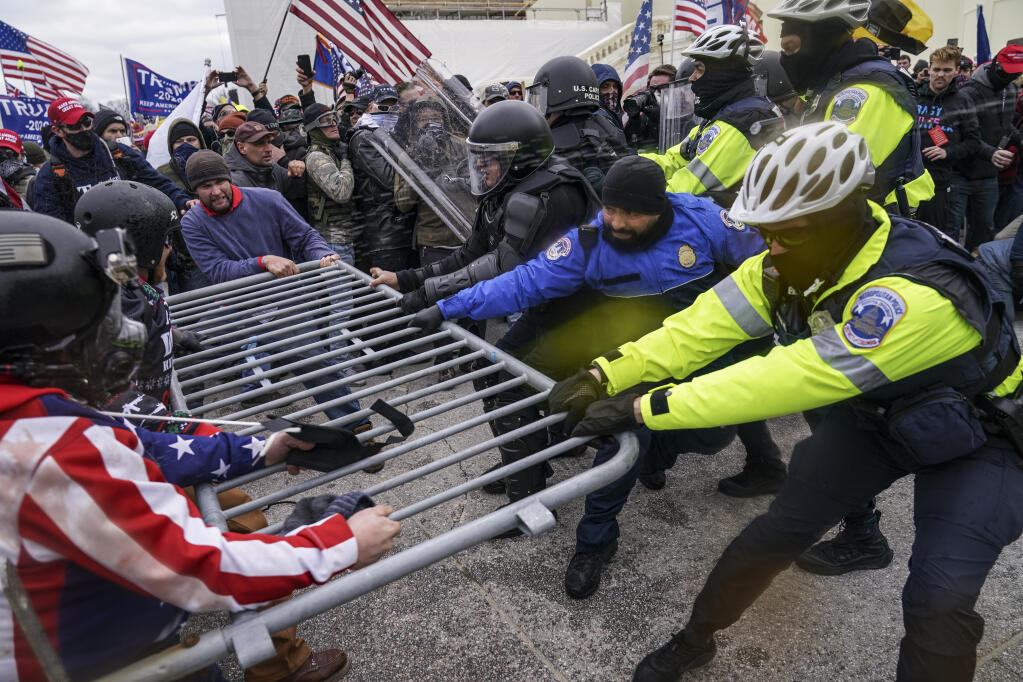 FILE - In this Jan. 6, 2021, file photo, Trump supporters try to break through a police barrier at the Capitol in Washington. (AP Photo/John Minchillo, File)