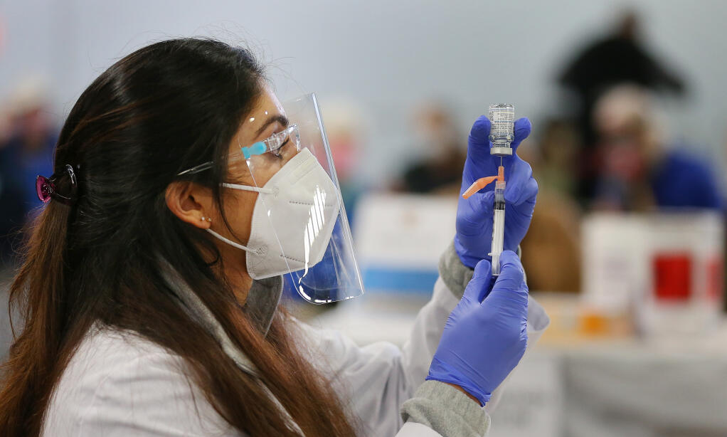 Safeway pharmacist Komal Kaur prepares a syringe with the Moderna COVID-19 vaccine at a coronavirus vaccination site at the Sonoma County Fairgrounds in Santa Rosa on Wednesday, February 3, 2021.  (Christopher Chung/ The Press Democrat)