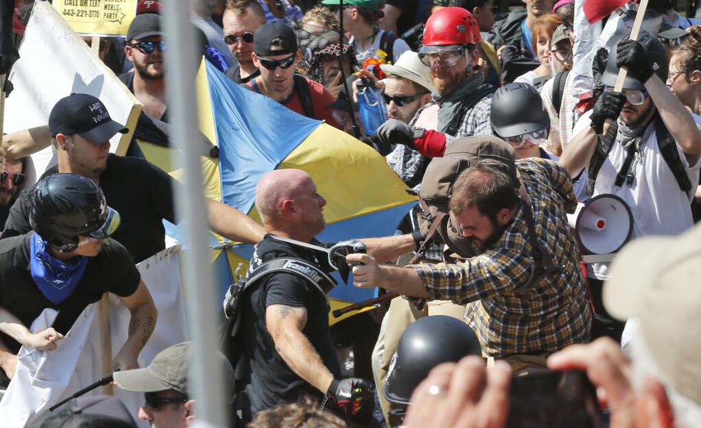 FILE - In this Aug. 12, 2017 file photo, white nationalist demonstrators clash with counter demonstrators at the entrance to Lee Park in Charlottesville, Va.  U.S. District Judge Norman Moon on Friday, Oct. 16, 2020, sentenced 26-year-old Cole Evan White to 14 months in prison but gave him credit for 7 months he served in jail after his arrest and 5 months of home confinement.  (AP Photo/Steve Helber, File)