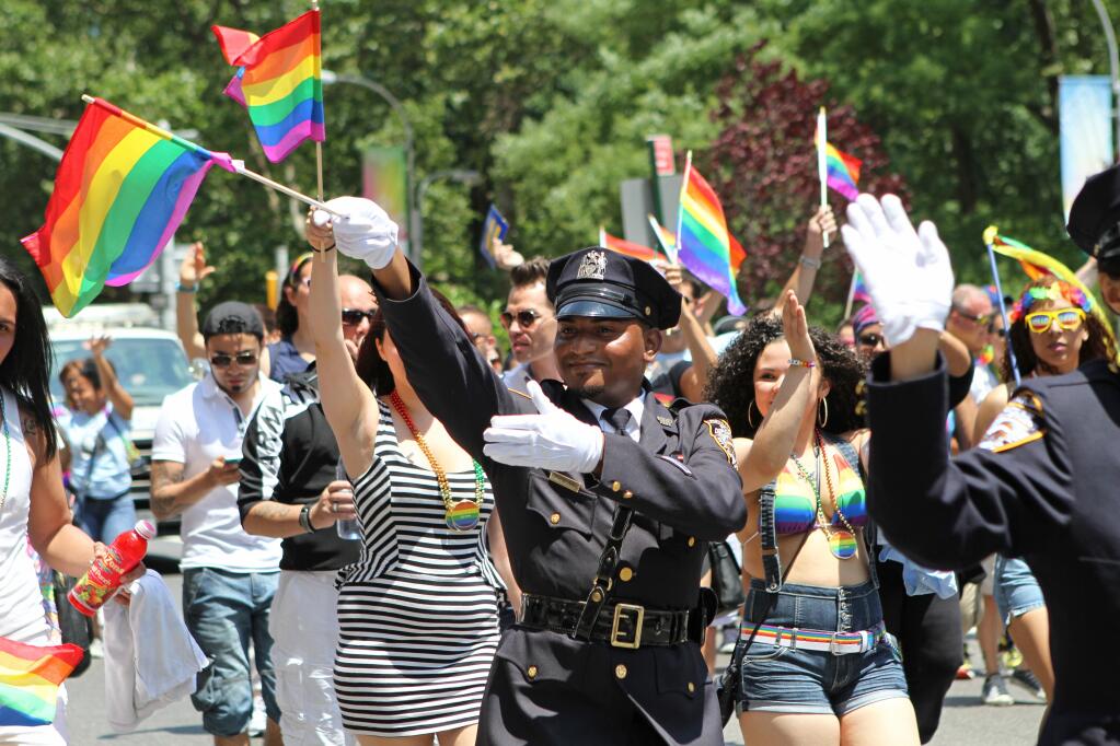FILE - In this Sunday, June 29, 2014 file photo, NYPD police officers march along Fifth Avenue during the gay pride parade in New York.  Organizers of New York City’s Pride events said Saturday, May 15, 2021 they are banning police and other law enforcement from marching in their huge annual parade until at least 2025 and will also seek to keep on-duty officers a block away from the celebration of LGBTQ people and history. (AP Photo/Julia Weeks, File)