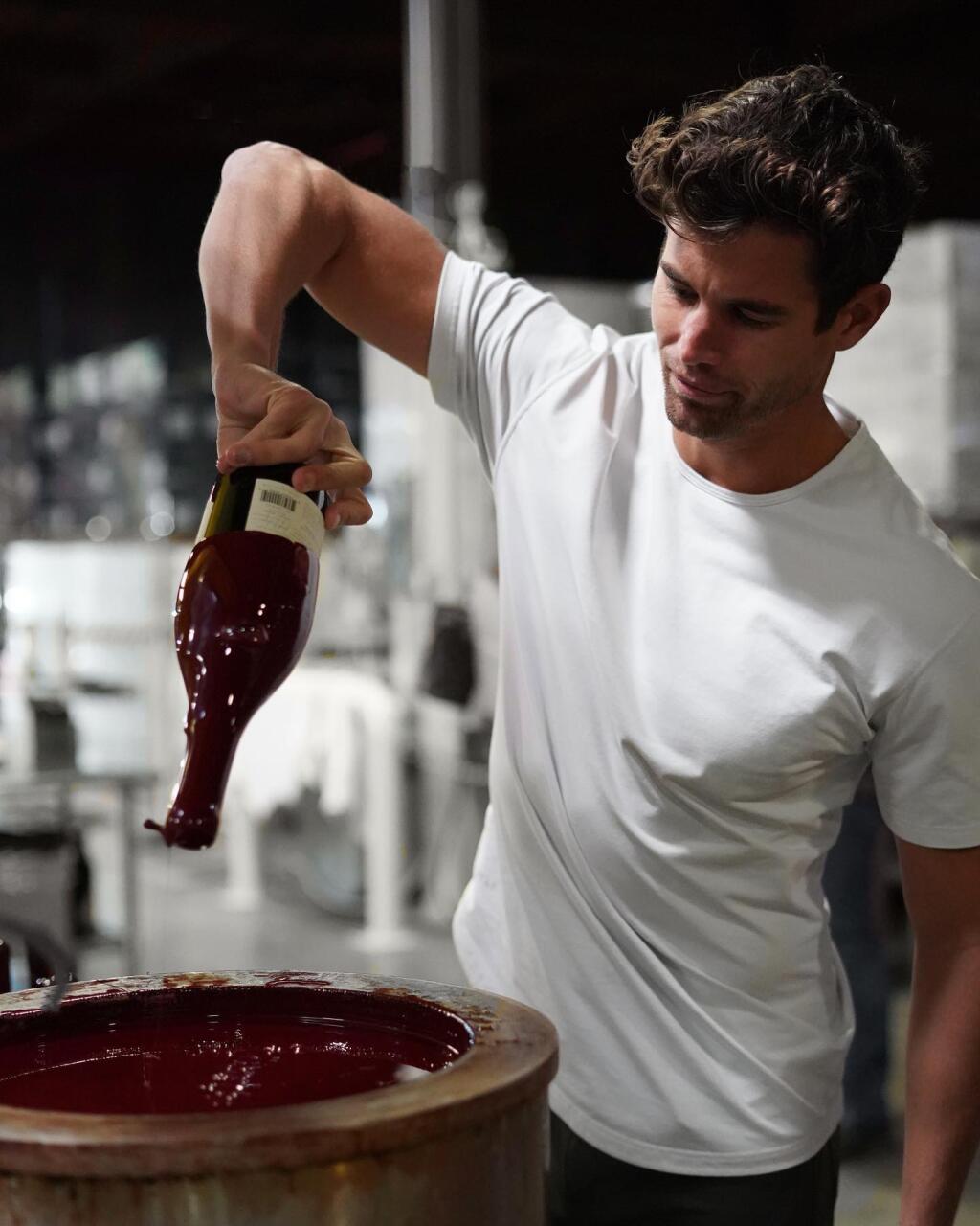 Chasen Nick, contestant on season 16 of “The Bachelorette,” dips a wine bottle in wax during his visit to Belle Glos. (Copper Cane Wines)