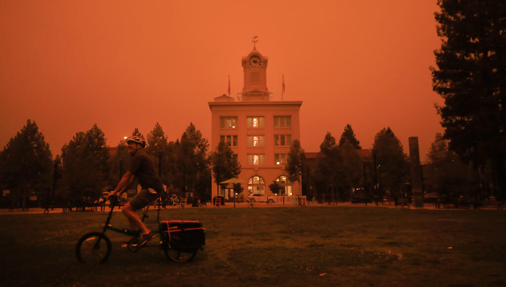 Bob Stender of Santa Rosa rides his bike at Old Courthouse Square, Wednesday, Sept. 9, 2020 as smoke from California wildfires foul the air. (Kent Porter / The Press Democrat) 2020