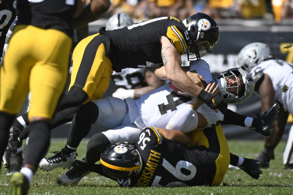 Las Vegas Raiders quarterback Derek Carr (4) is sacked by Pittsburgh Steelers linebacker Robert Spillane, top, and linebacker Alex Highsmith (56) during the first half of an NFL football game in Pittsburgh, Sunday, Sept. 19, 2021. (AP Photo/Don Wright)
