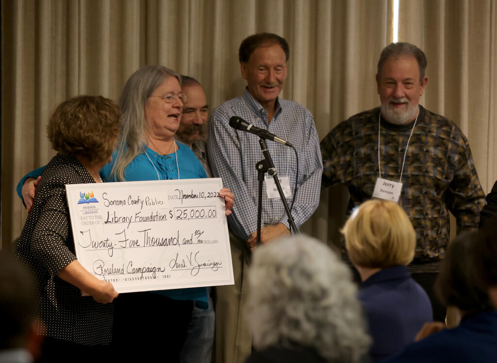 Sarah Swearingen, second from left, of Friends of the Santa Rosa Libraries, presents a $25,000 check to the Sonoma County Public Library Foundation during a campaign launch event at the Central Santa Rosa Library in Santa Rosa, Calif., Thursday, November 10, 2022. (Beth Schlanker/The Press Democrat)