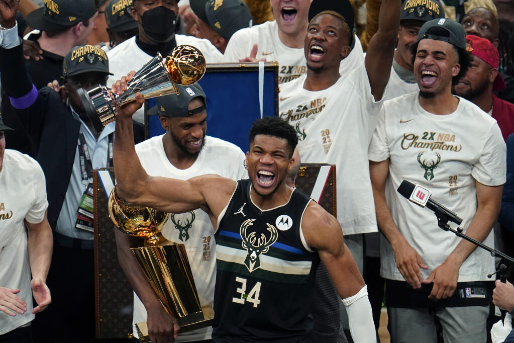 Milwaukee Bucks forward Giannis Antetokounmpo (34) holds with the finals MVP trophy after the Bucks defeated the Phoenix Suns in Game 6 of basketball's NBA Finals in Milwaukee, Tuesday, July 20, 2021. The Bucks won 105-98. (AP Photo/Paul Sancya)