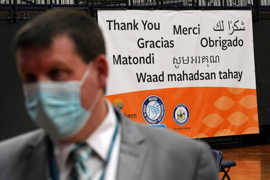 A banner says thanks in several languages at a COVID-19 vaccination clinic in Portland, Maine. (ROBERT F. BUKATY / Associated Press)