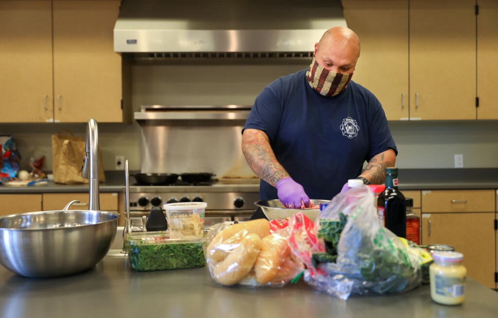 Jacob Mual prepares the meat for his BBQ Pork Meatball Heroes at the Graton Fire Department on Tuesday, March 30, 2021.  (Christopher Chung / The Press Democrat)