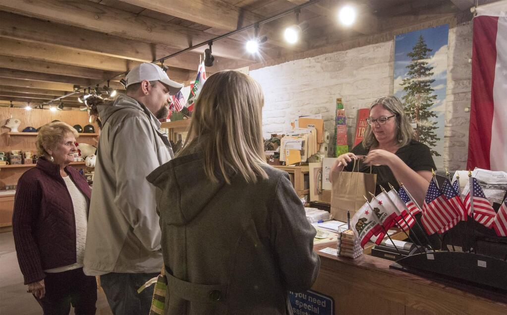 Jan Oneto, assistant manager at the Barracks Gift Shop, wraps up some purchases from Justin and Bobbie Timms, who came from Tacoma, Wash., to visit their aunt, Deanna Machado (far left) and take in the pleasures of visiting the Valley. (Photo by Robbi Pengelly/Index-Tribune)