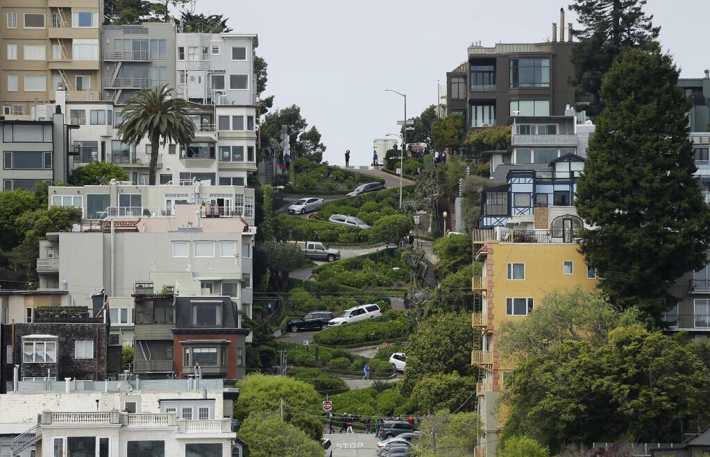FILE - In this April 15, 2019, file photo, cars wind their way down Lombard Street in San Francisco. (AP Photo/Eric Risberg, File)
