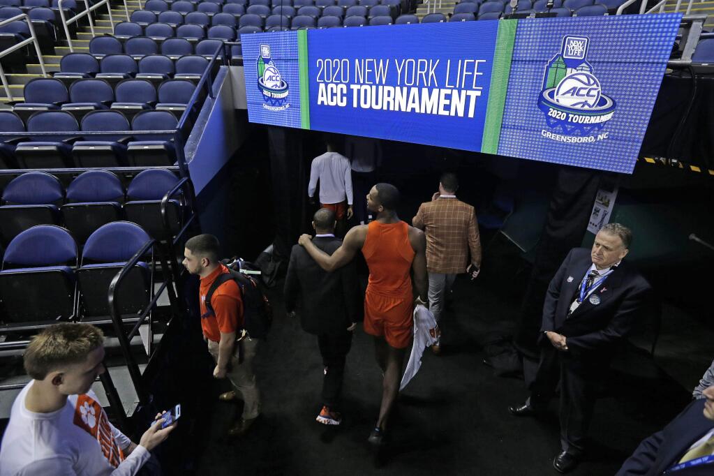 Clemson players leave the floor after the NCAA basketball games at the Atlantic Coast Conference tournament were canceled due to concerns over the coronavirus in Greensboro, N.C., Thursday, March 12, 2020. (AP Photo/Gerry Broome)