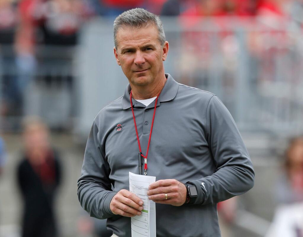 In this April 14, 2018, file photo, Ohio State coach Urban Meyer watches the NCAA college football team's spring game in Columbus, Ohio. Ohio State has placed Meyer on paid administrative leave while it investigates claims that his wife knew about allegations of abuse against an assistant coach years before he was fired last week. (AP Photo/Jay LaPrete, File)