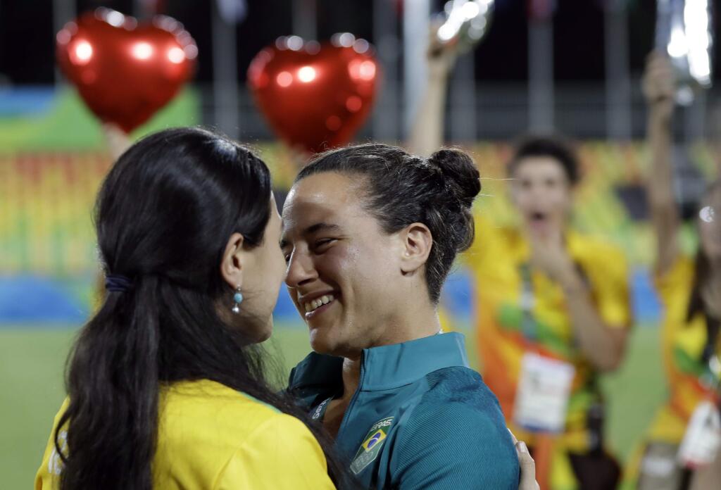 Brazil's Isadora Cerullo, right, shares a moment with her partner Marjorie Enya, after she was asked her to marry her, after the medal ceremony for the women's rugby sevens match at the Summer Olympics in Rio de Janeiro, Brazil, Monday, Aug. 8, 2016. (AP Photo/Themba Hadebe)