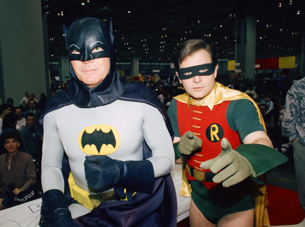 FILE - In this Jan. 27, 1989 file photo, actors Adam West, left, and Burt Ward dress as their characters Batman and Robin respectively during an appearance at the 'World of Wheels' custom car show in Chicago. The actors are voicing their characters in an animated film, 'Batman: Return of the Caped Crusaders,' that will be released digitally on Oct. 11 and on Blu-ray on Nov. 1. (AP Photo/Mark Elias, File)
