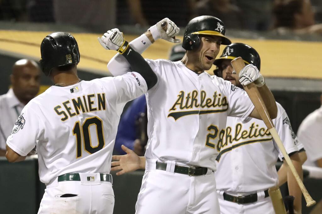 The Oakland Athletics' Marcus Semien (10) celebrates with Matt Olson, right, after hitting a home run against the Texas Rangers during the fifth inning Saturday, Sept. 21, 2019, in Oakland. (AP Photo/Ben Margot)