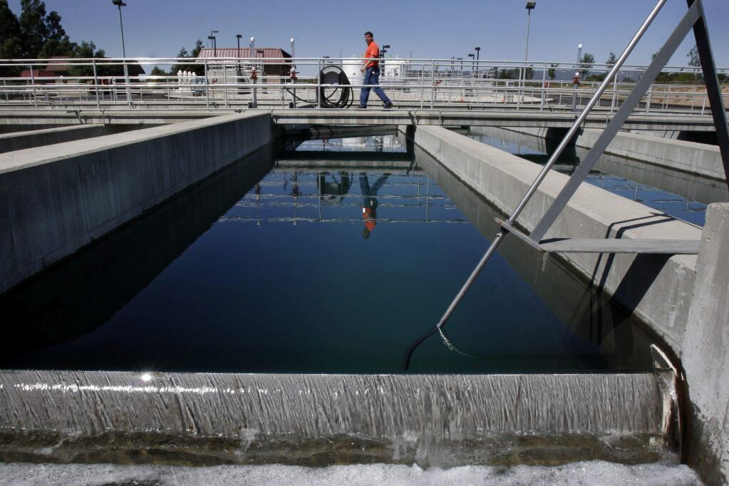 A plant operator walks along a catwalk above the chlorine contact chamber, the last step in wastewater treatment at the Sonoma Valley sewage treatment plant. (PD file)