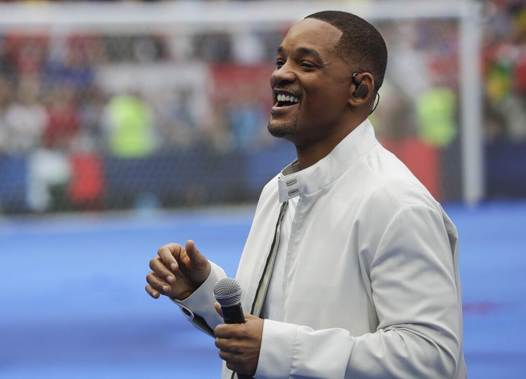 FILE - In this July 15, 2018, file photo, singer and actor Will Smith performs during the closing ceremony prior to the final match between France and Croatia at the 2018 soccer World Cup in the Luzhniki Stadium in Moscow, Russia. The star on Wednesday, Oct. 10, revealed the first poster of Disney's remake of 'Aladdin.' Smith, who plays the Genie, wrote on Facebook: 'LEMME OUT! Can't wait for y'all to see Me BLUE.' (AP Photo/Matthias Schrader, File)