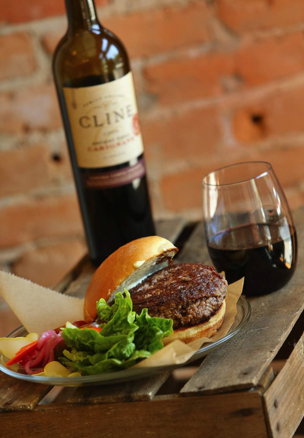 Bacon and grass-fed beef burger created by Travis Day, owner and butcher of Thistle Meats in Petaluma. The burger is paired with Cline Family Cellars 2014 Carignane.(Christopher Chung/ The Press Democrat)