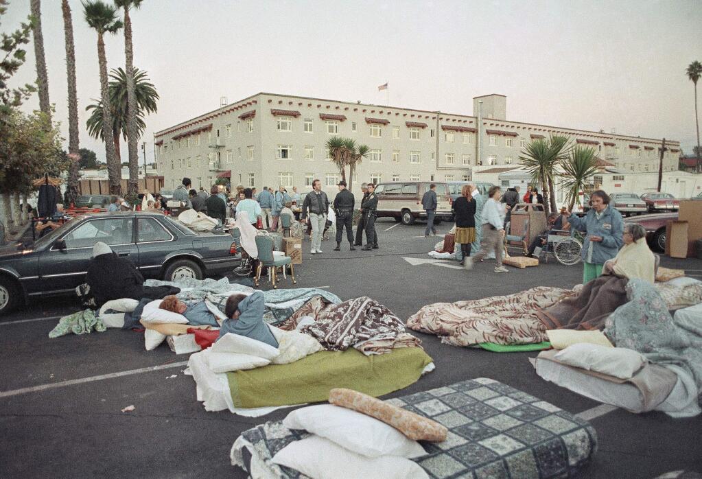 A Santa Cruz parking lot resembled a campground, Wednesday, Oct. 18, 1989 in Santa Cruz after an earthquake measuring a 6.9 on the Richter scale. The quake forced the evacuation of a retirement hotel and residents were forced to sleep in spaces normally reserved for cars. (AP Photo/Douglas C. Pizac, 1989)