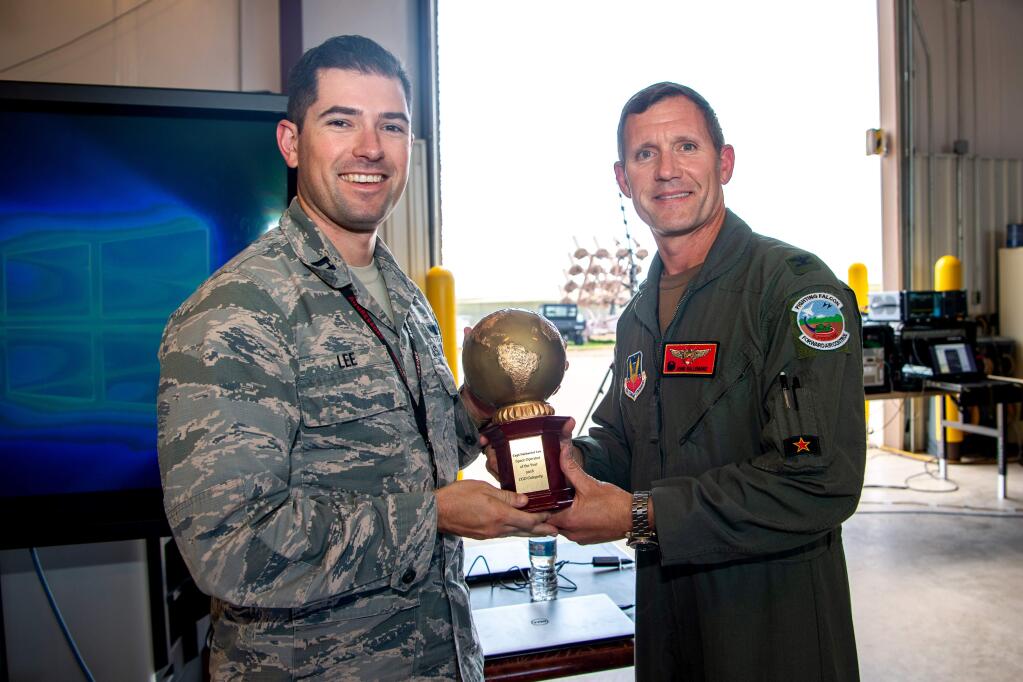 Col. John Gallemore, 57th Adversary Tactics Group commander, presents the U.S. Air Force Space Operator of the Year, company grade officer category, award to Capt. Nathaniel Lee, 527th Aggressor Squadron chief of future operations, at the 527th SAS barn, Schriever Air Force Base, Colorado, Aug. 15, 2019. (U.S. Air Force photo by Kathryn Calvert)