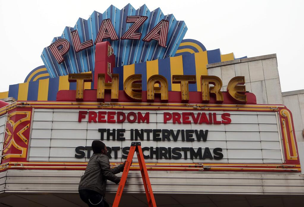 Brandon Delaney, general manager of the Plaza Theatre, in Atlanta, Ga., finishes hanging the marquis Tuesday, Dec. 23, 2014 to announce that the theatre will be showing 'The Interview.' The Interview was put back into theaters Tuesday when Sony Pictures Entertainment announced a limited Christmas Day theatrical release for the comedy that provoked an international incident with North Korea and outrage over its cancelled release. (AP Photo/Atlanta Journal-Constitution, Ben Gray)
