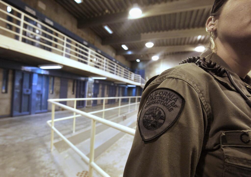 FILE - This Aug. 17, 2011 file photo shows a correctional officer in one of the housing units at Pelican Bay State Prison near Crescent City, Calif. Officials say several California prison guards and inmates were taken to hospitals after a fight between two inmates quickly raged out of control Wednesday, May 24, 2017. (AP Photo/Rich Pedroncelli, File)