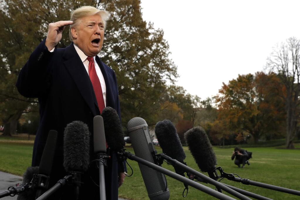 President Donald Trump talks to the media before boarding Marine One on the South Lawn of the White House, Friday, Nov. 9, 2018, in Washington. (AP Photo/Evan Vucci)