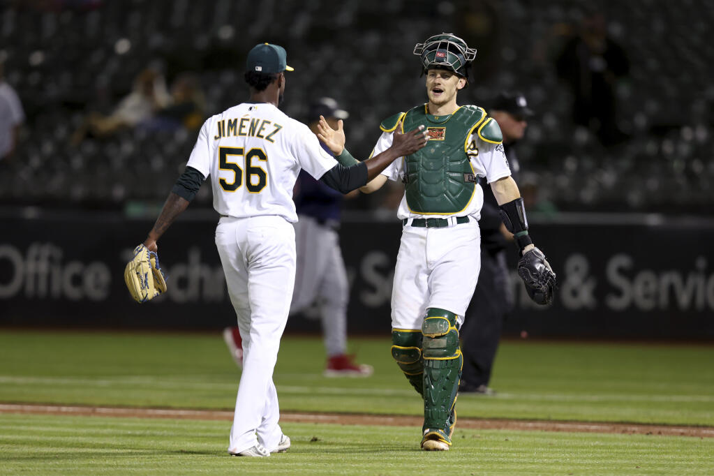 The Athletics’ Dany Jimenez celebrates with Sean Murphy, right, after defeating the Minnesota Twins in Oakland on Tuesday, May 17, 2022. (Jed Jacobsohn / ASSOCIATED PRESS)