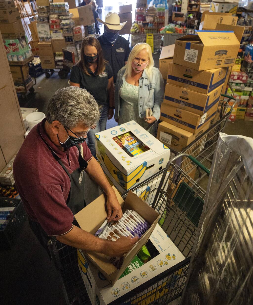 Joe Molsberry, owner of Molsberry’s Market,  goes through an inventory of snacks with Stephanie, Lori and Robbie Bisordi on Thursday, July 16, 2020. Stephanie and Robert Bisordi, who have been farming the same River Road ranch for generations, started Lunches for Lifesavers to bring meals to Sutter Hospital workers during the coronavirus pandemic. (John Burgess/The Press Democrat)