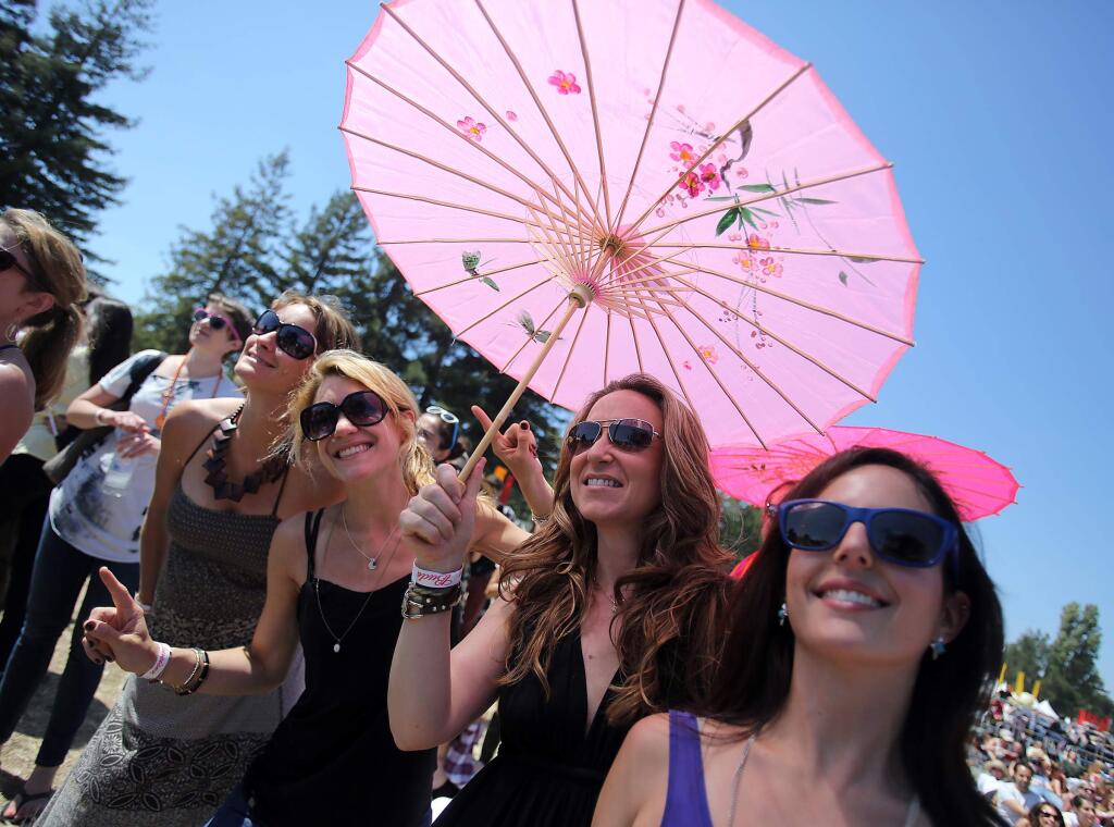 San Francisco residents from right to left, Mia Gralla, Kristin Hersant and Hannah Tecott keep cool under an umbrella as they groove to the music of Vintage Trouble at the Willpower Stage during Bottlerock 2013 held in Napa, Friday, May 10, 2013. (Crista Jeremiason / Press Democrat)