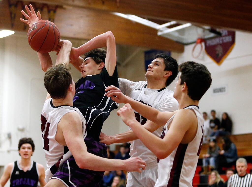 Petaluma's Joey Potts (45), second from left, goes for a shot and draws a foul while surrounded by Healdsburg's Landon Courtman (24), left, Juan Aguilar (22), and Desmond Swan (20), right, during the second half of a boys varsity basketball game between Petaluma and Healdsburg high schools in Healdsburg, California on Tuesday, January 3, 2017. (Alvin Jornada / The Press Democrat)