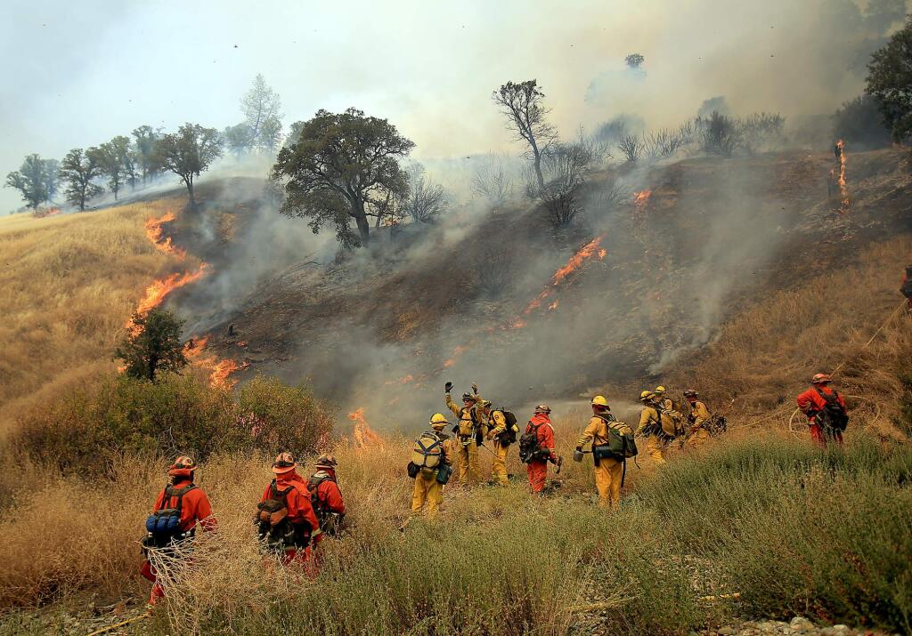 More hose is requested as crews head up the hill where the Rocky Fire jumped Highway 20, east of Spring Valley, Monday Aug. 3, 2015 in Lake County. (Kent Porter / Press Democrat) 2015