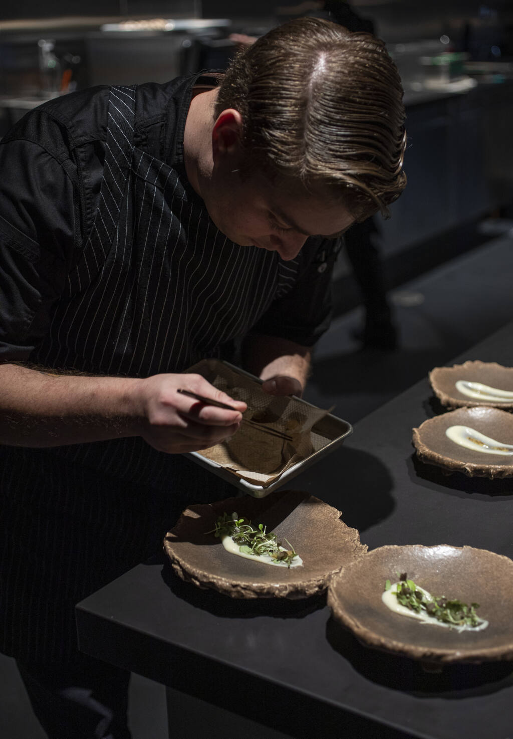 During a family and friends pre-opening night aged Gouda, pear, pretzel and mustard are plated for service at Cyrus in Geyserville, Thursday Sept. 8, 2022. (Chad Surmick/The Press Democrat file)
