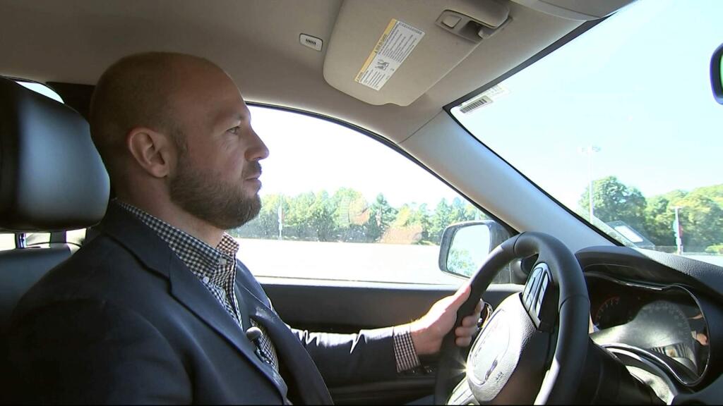 In this image from video, Jake Nelson, AAA's director for traffic safety advocacy and research drives one of the test vehicles used in the study in Washington, Wednesday, Oct. 4, 2017. Infotainment technology automakers are cramming into the dashboard of new vehicles is making drivers take their eyes off the road and hands off the wheel for dangerously long periods of time, a study being released by AAA on Oct. 5 says. (AP Photo/Bill Gorman)