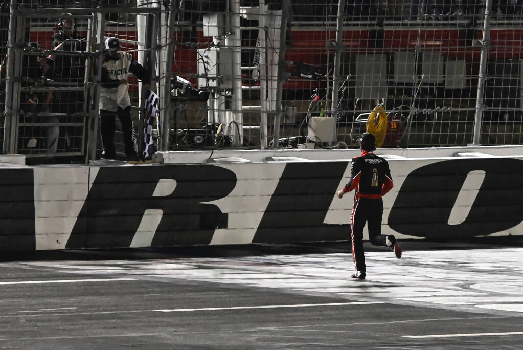 Ryan Blaney runs up the track to grab the checkered flag after winning a NASCAR Cup Series auto race at Charlotte Motor Speedway, Monday, May 29, 2023, in Concord, N.C. (AP Photo/Matt Kelley)