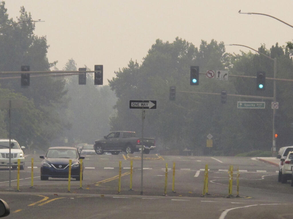 Smoke from wildfires in neighboring California blankets neighborhood streets in suburban Sparks, Nev., just east of Reno, Monday, Aug. 23, 2021. The Washoe County School District closed all schools including those in Reno, Sparks and parts of Lake Tahoe on Monday due to the hazardous air quality. The county health district urged the general public to "stay inside as much as possible" due to conditions expected to continue through Wednesday. (AP Photo/Scott Sonner)