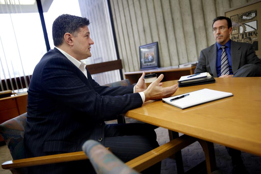 Santa Rosa City Manager Sean McGlynn, left, talks with David Gouin, the Director of Economic Development and Housing, and Assistant City Manager Chuck Regalia, not shown, during a meeting in his office in Santa Rosa, California on Monday, January 5, 2015. (BETH SCHLANKER/ The Press Democrat)