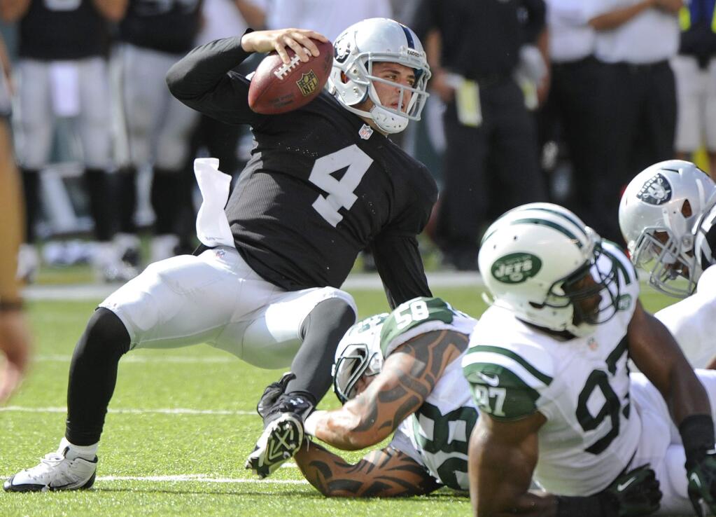 Oakland Raiders quarterback Derek Carr (4) is sacked by New York Jets' Jason Babin (58) during the second half of an NFL football game Sunday, Sept. 7, 2014, in East Rutherford, N.J. The Jets won the game 19-14. (AP Photo/Bill Kostroun)
