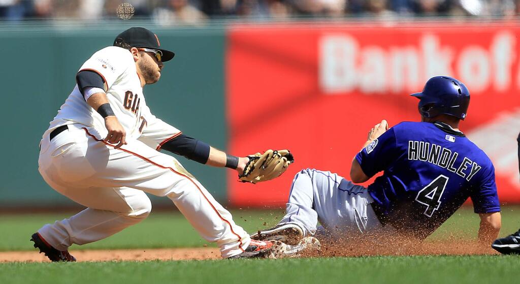 Brandon Crawford tags out a stealing Nick Hundley during the Giants home opener against the Rockies, Monday April 13, 2015 at AT&T Park in San Francisco. (Kent Porter / Press Democrat) 2015