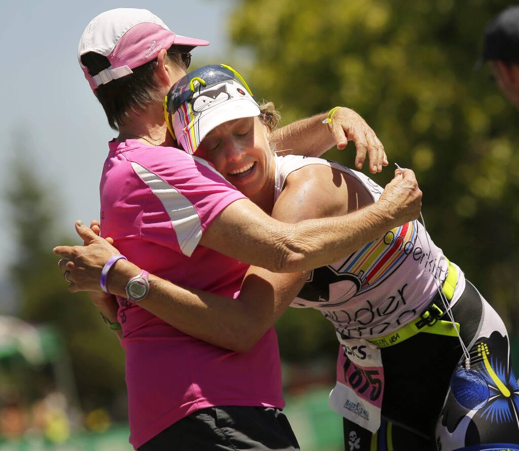 Liza Rachetto hugs Barbara Recchia after finishing first in Barb's Race at the Vineman Triathlon in Windsor on Friday, July 18, 2014. (Conner Jay/The Press Democrat)