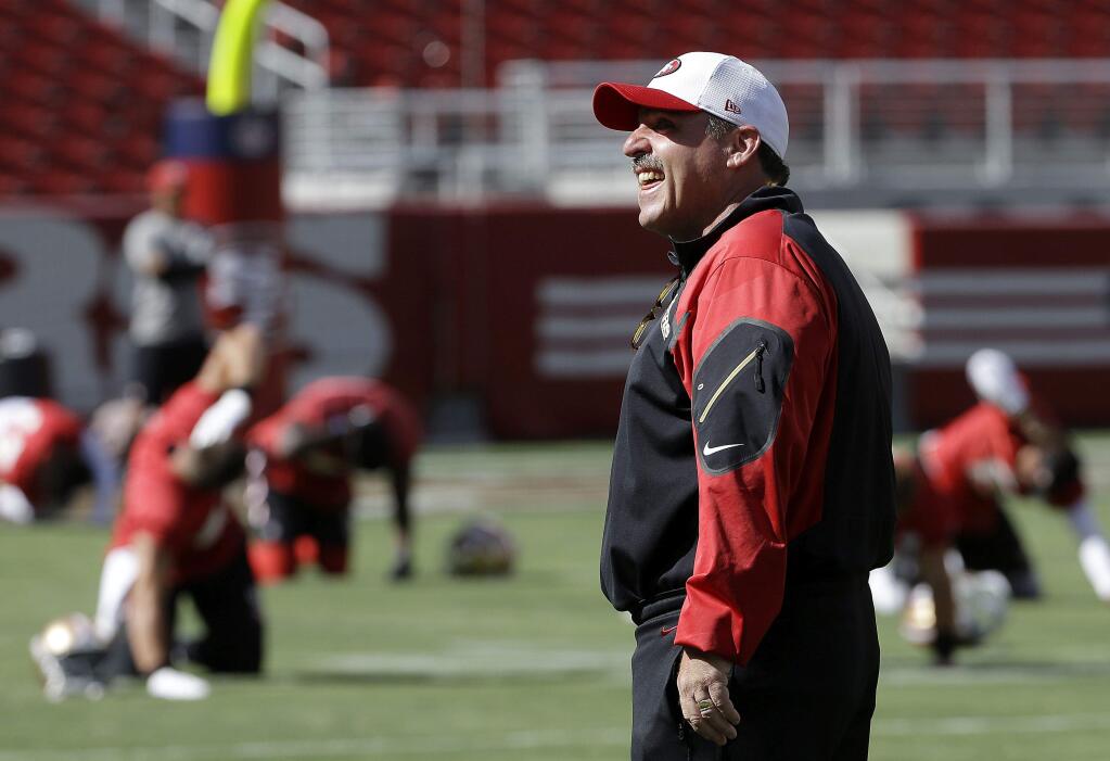 49ers head coach Jim Tomsula smiles while watching his team practice at Levi's Stadium in Santa Clara. (Jeff Chiu / Associated Press)