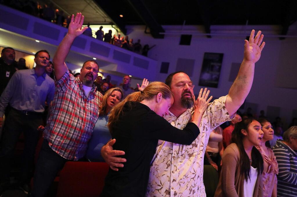 Chris and Sara Keys, foreground, and Angel and Craig Clark, left, sing during and area-wide prayer service held at the Redwood Covenant Church, in Santa Rosa on Sunday, October 15, 2017. (Christopher Chung/ The Press Democrat)