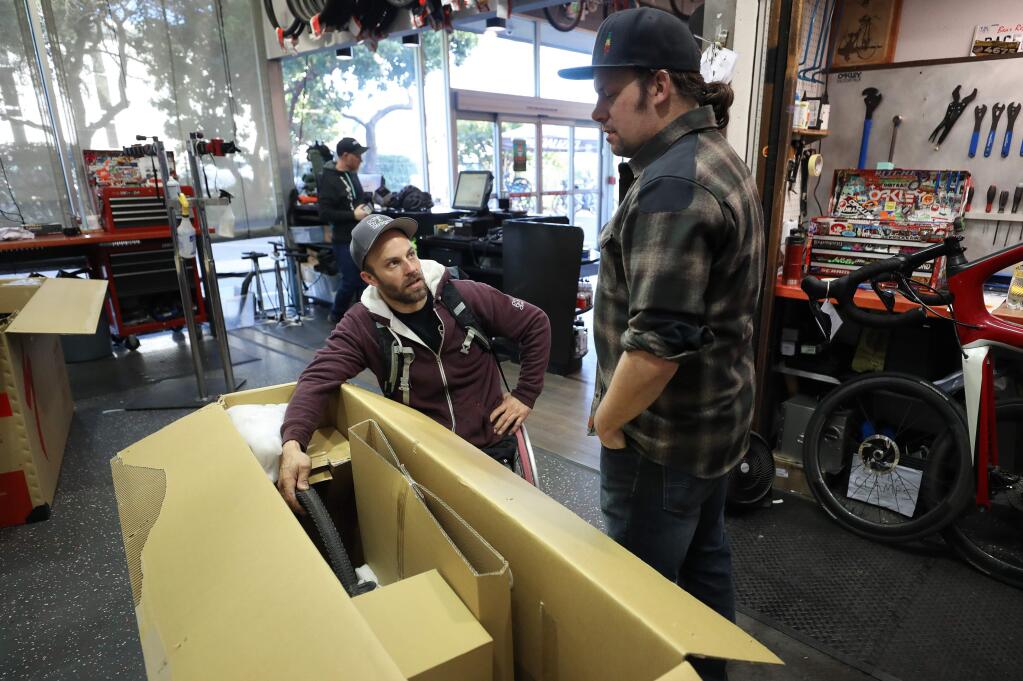 Andre Kajlich, left, talks with NorCal Bike Sport service manager Preston Theler in Santa Rosa on Tuesday, February 4, 2020 about the proper bike tire pressure for his upcoming cycling and mountain-climbing expedition in South America. (Christopher Chung / The Press Democrat)