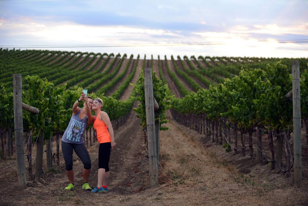 Marisa Spencer, left, from Pittsburgh, Pennsylvania and Madlyn Oltman of Charleston, West Virginia, taking selfies near a vineyard at Cuvaison Estate Wines in Napa before the start of the Napa-to-Sonoma Wine Country Half Marathon held on July 19, 2015. (Photo: Erik Castro/for The Press Democrat)