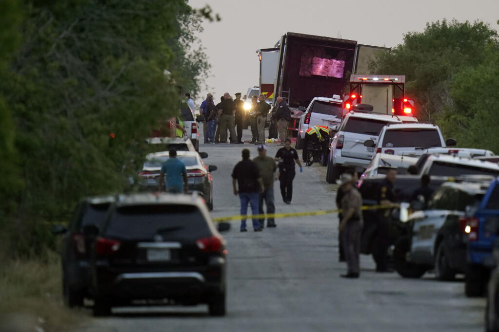 FILE - Police and other first responders work the scene where officials say dozens of people have been found dead and multiple others were taken to hospitals with heat-related illnesses after a tractor-trailer containing suspected migrants was found on June 27, 2022, in San Antonio. Officials said two men were indicted Wednesday, July 20 in the case.  (AP Photo/Eric Gay, File)