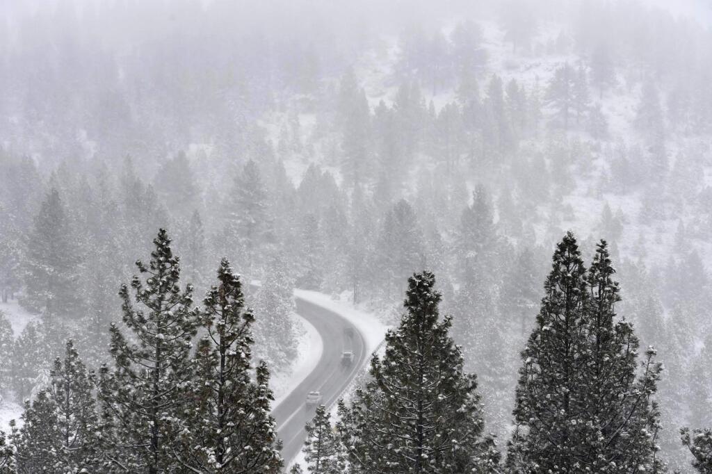 This Nov. 20, 2019, photo shows traffic moving slowly along the Mount Rose Highway after a good dusting of snow covered the mountains near Reno, Nev. Thanksgiving travel is an ordeal under the best of circumstances, and a one-two punch of bad weather threatens to make it even more exhausting. (Andy Barron/The Reno Gazette-Journal via AP)