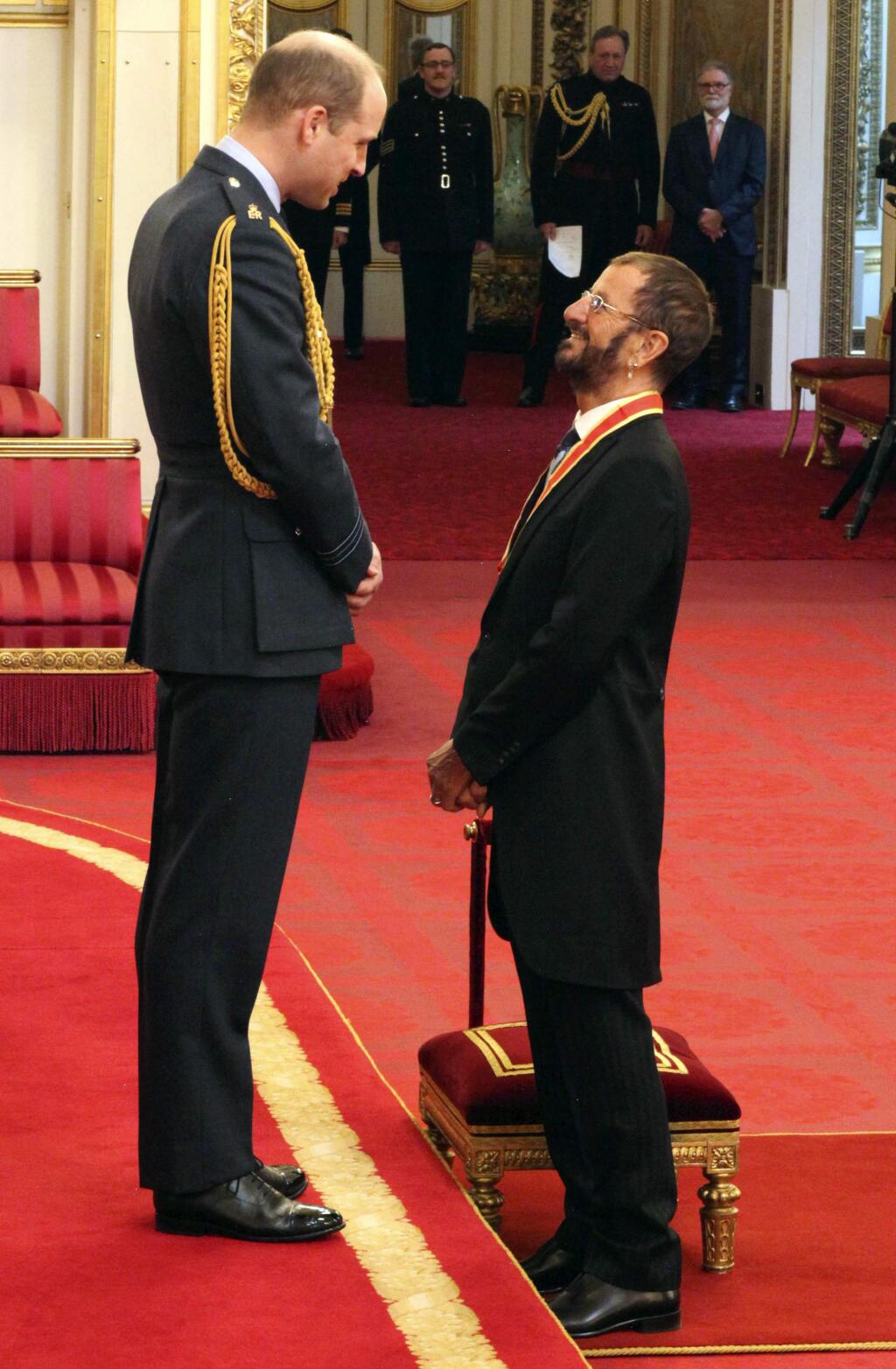 Former Beatle Ringo Starr, speaks with Britain's Prince William after receiving his knighthood at Buckingham Palace during an Investiture ceremony in London Tuesday March 20, 2018. (Yui Mok/PA via AP)