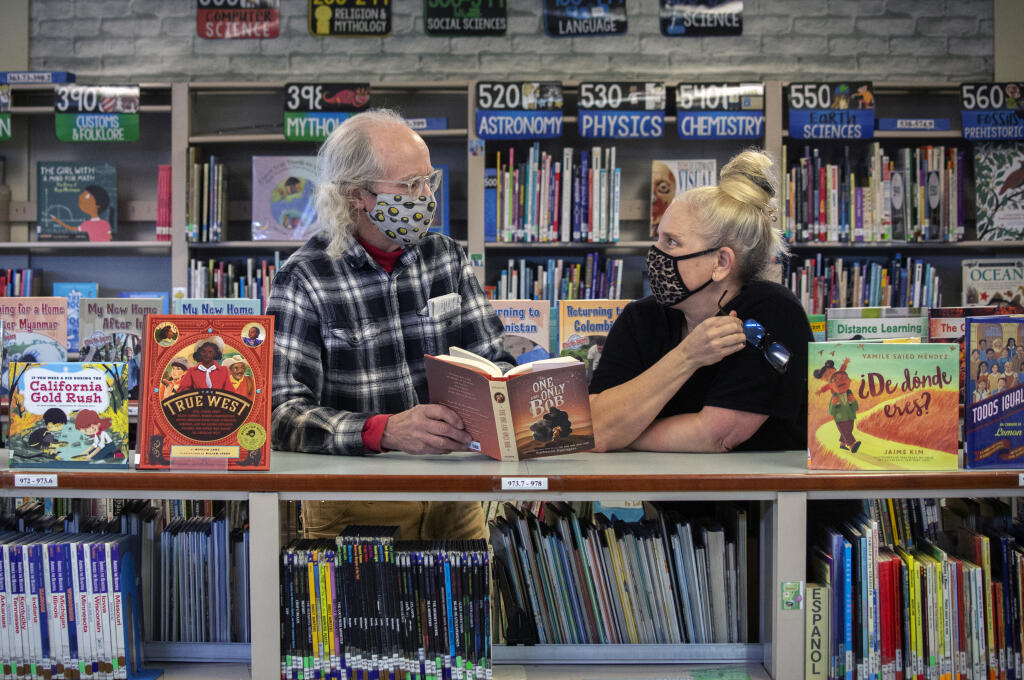 Tony Pisacane brings a new book and chats with Sassarini Elementary School librarian Danielle Smith on Thursday, Jan. 6, 2022. (Robbi Pengelly/Index-Tribune)